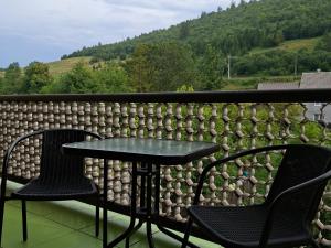 a table and two chairs on a balcony with mountains at Oleksandria in Volovets +21 photos