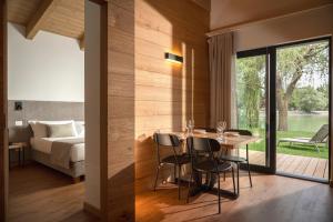 a dining room with a table and chairs and a bedroom at The Village Chalet in Castel di Sangro