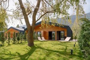a house with a tree in the yard at The Village Chalet in Castel di Sangro