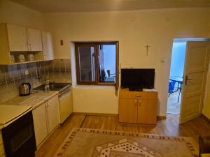 a kitchen with a tv on a counter and a window at Lila apartments in Bijakovići +4 photos