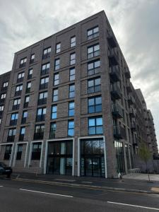 a large brick building with windows on a street at Berkeley Square Apartments by StaySavvy Accommodation in Manchester