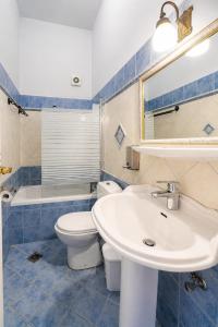 a bathroom with a sink and a toilet and a mirror at Archontiko Eleni Hotel in Andros +39 photos