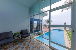 a living room with a swimming pool and glass walls at Private Ocean-View Pool Villa, Phan Thiet Beach in Tiến Thành
