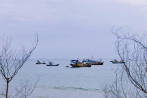 a group of boats sitting in the water at Private Ocean-View Pool Villa, Phan Thiet Beach in Tiến Thành