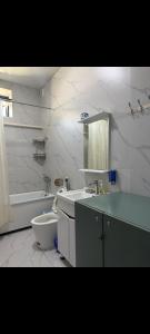 a white bathroom with a tub and a sink and a bath tub at Deutsch Hostel Osh in Osh +35 photos