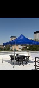 a blue tent over a table and two benches at Deutsch Hostel Osh in Osh