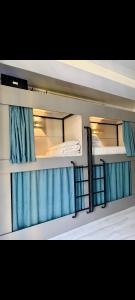 two bunk beds in a room with blue curtains at Deutsch Hostel Osh in Osh