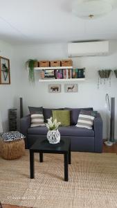 a living room with a blue couch and a table at Bispgården Paradis in Bispgården