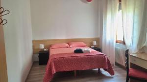 a small bedroom with a bed with a red blanket at Casa Kendra in Montegrotto Terme