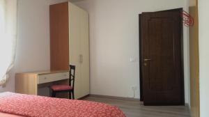 a bedroom with a bed and a desk and a door at Casa Kendra in Montegrotto Terme