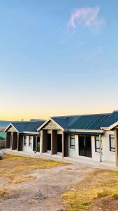 a row of buildings with blue roofs at MAISON MOSH ll GUEST HOUSE in Maseru