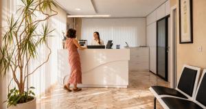 a woman standing at a counter in an office at Apartamentos Vértice Bib Rambla in Seville +18 photos