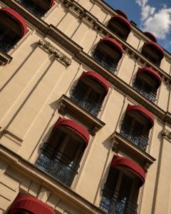 a tall building with red balconies on it at Hôtel Derby Eiffel in Paris