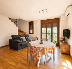 a living room with a table and a couch at Apartaments Sort Pirineus in Sort