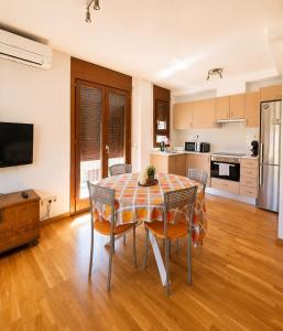 a kitchen and dining room with a table and chairs at Apartaments Sort Pirineus in Sort