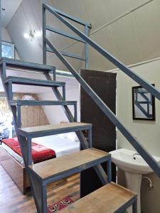 a staircase in a room with a bed and a sink at Monal Nests in Champawat