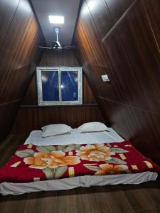 a bedroom with a bed with a blanket on it at Monal Nests in Champawat +23 photos