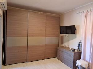 a large wooden closet with a tv on a wall at Le due Rive in Tufo