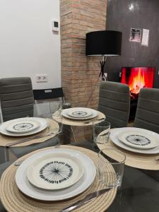 a table with plates on it with chairs and a fireplace at 3-Bedroom Home, Free Parking,10 Minutes from Seville in Camas