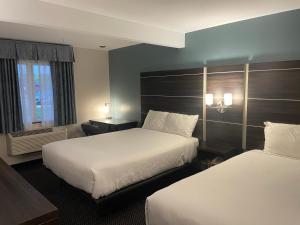 a hotel room with two beds and a window at Landmark Inn in Osawatomie