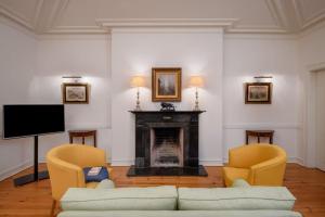 a living room with a couch and two chairs and a fireplace at Hotel Casa Palmela - Small Luxury Hotels of The World, Hotel & Villas in Setúbal