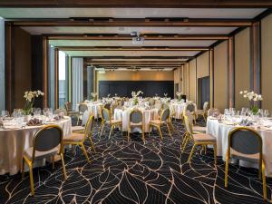 a banquet room with tables and chairs and a screen at Movenpick Hotel Tallinn in Tallinn +120 photos