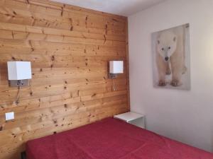 a bedroom with a wooden wall with a red bed at Appartement 2 pièces rénové 5 pers. au cœur des pistes - FR-1-181-952 in Plagne Bellecote
