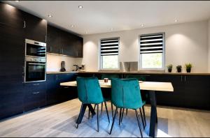 a kitchen with a wooden table and blue chairs at Eh ma biche in Stoumont