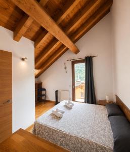 a bedroom with a large bed with wooden ceilings at Apartaments Sort Pirineus in Sort +52 photos