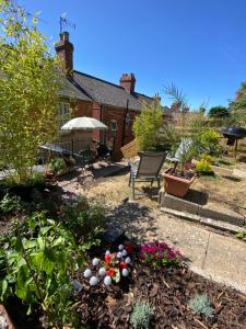 a backyard with a garden with flowers and plants at Glen Villa - 3 bedroom house - Stroud town centre in Stroud