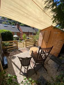 a patio with a chair and a wooden shed at Glen Villa - 3 bedroom house - Stroud town centre in Stroud +33 photos