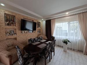 a living room with a table and chairs and a couch at Oleksandria in Volovets