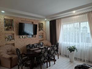 a living room with a table and chairs and a television at Oleksandria in Volovets