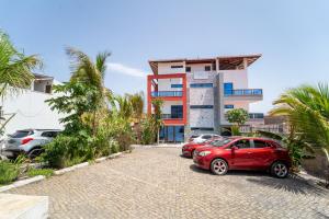 two cars parked in a parking lot in front of a building at Hotel Cantinho in Montanha