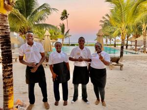 a group of people standing on the beach at Infinity Beach Boutique Hotel & SPA in Matemwe