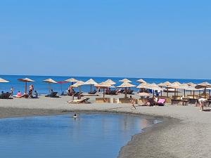 a beach with many umbrellas and people on the beach at Kućica Dva Dječaka in Ulcinj