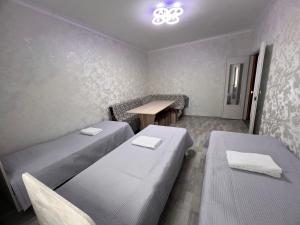 a small room with two beds and a table at Altyn Sandyk in Karakol