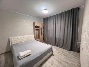 a bedroom with a bed with two towels on it at Altyn Sandyk in Karakol
