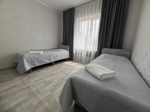 a hospital room with two beds and a window at Altyn Sandyk in Karakol +6 photos