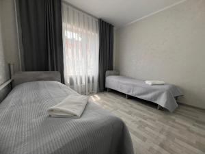 a hospital room with two beds and a window at Altyn Sandyk in Karakol