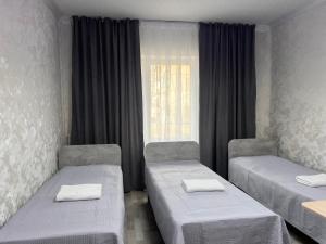 a room with two beds and a window at Altyn Sandyk in Karakol