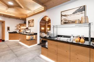 a kitchen with a large counter with a sink at Hotel Albona in Ischgl +115 photos