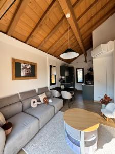 a living room with a couch and a table at EPIC CHALETS - 4 et 5 étoiles - Spa privatif - Gérardmer in Granges-Aumontzey