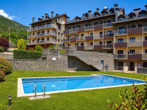 a hotel with a swimming pool in front of a building at Apartaments Sort Pirineus in Sort