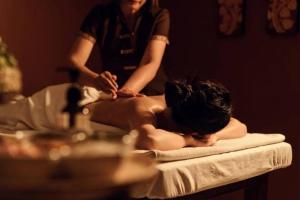 a woman laying on a bed in a bath room at Alltrue Lite Hotel Nagoya Hill Batam in Nagoya