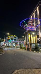 a city street at night with a building with neon lights at Alltrue Lite Hotel Nagoya Hill Batam in Nagoya