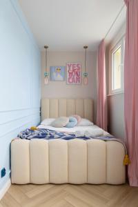 a bedroom with a large bed with pink curtains at Pastel Apartment - Ergo Arena in Gdańsk