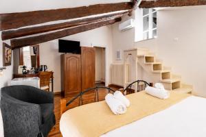 a bedroom with a bed and a chair and stairs at Archontiko Eleni Hotel in Andros