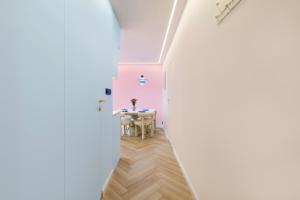 a hallway with a table in a room with pink walls at Pastel Apartment - Ergo Arena in Gdańsk