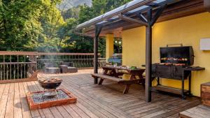 a patio with a grill and a television on a deck at Gapyeong Ruba Pension in Gapyeong